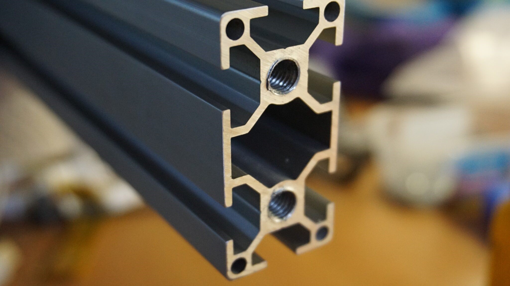 Cross-section profiles of an aluminum extrusion prototype next to a finished part, illustrating the complexity of custom extrusion prototyping.